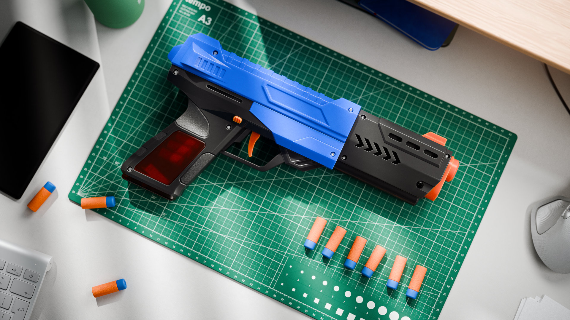 A blue, black and orange foam dart blaster lying on a green cutting mat on a desk, with foam darts lined up beside it